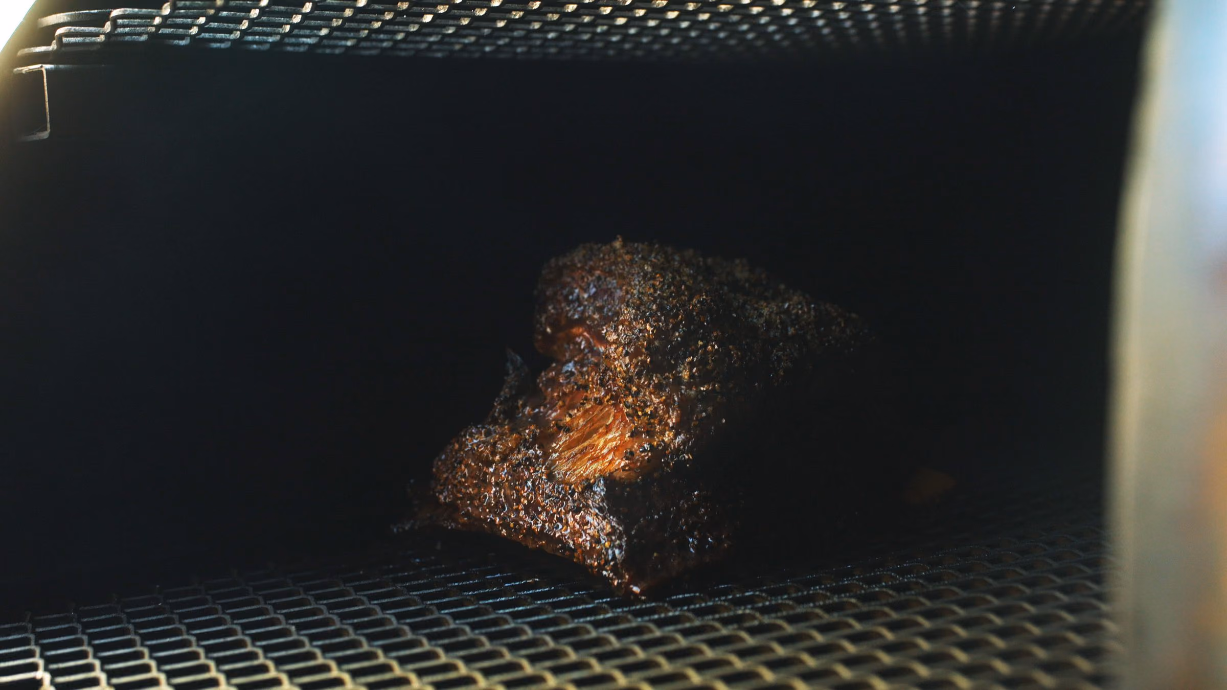 Brisket en cours de fumage dans la chambre du smoker, ambiance sombre