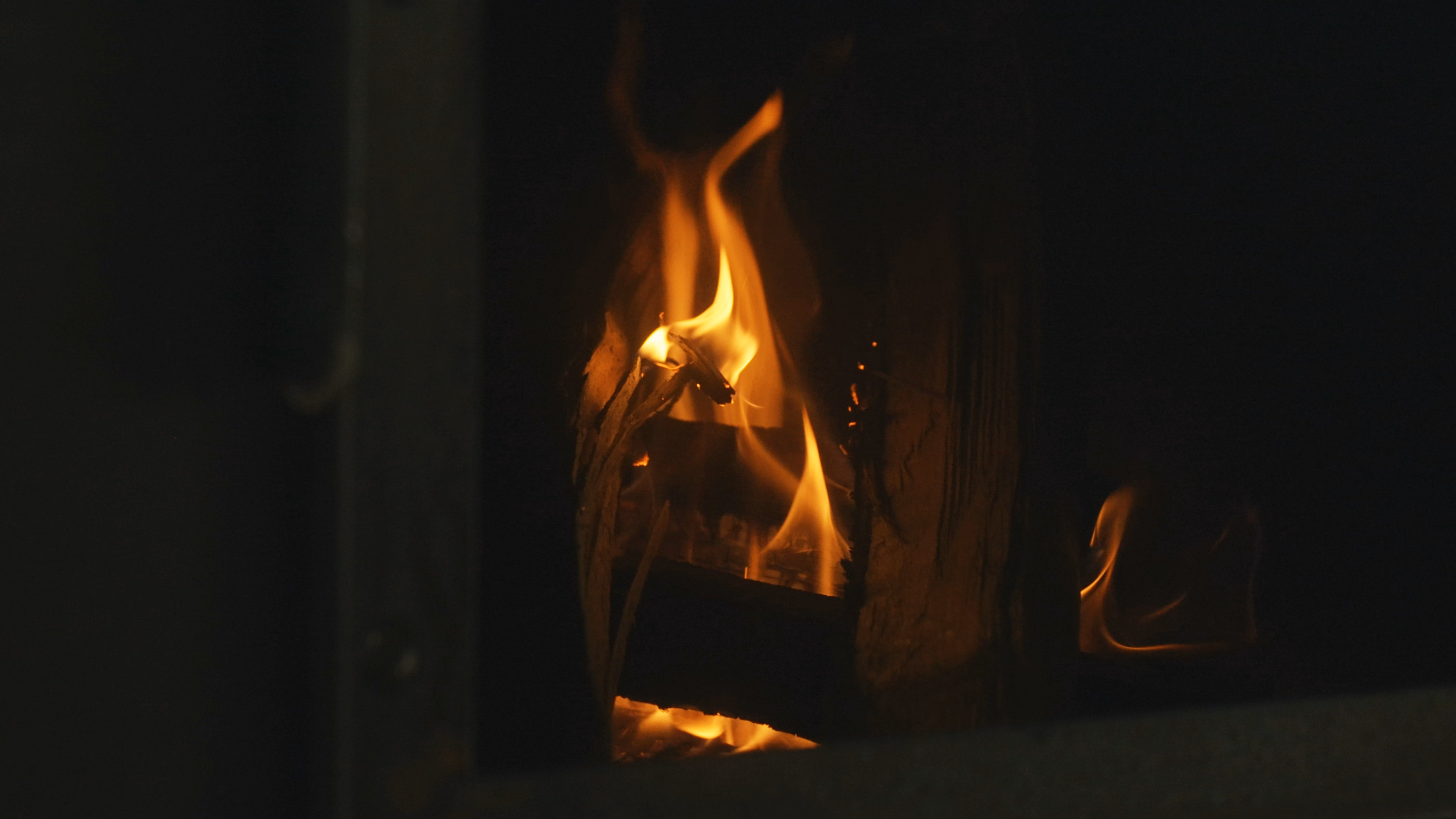 Feu de bois en pleine flamme dans le foyer déporté du smoker