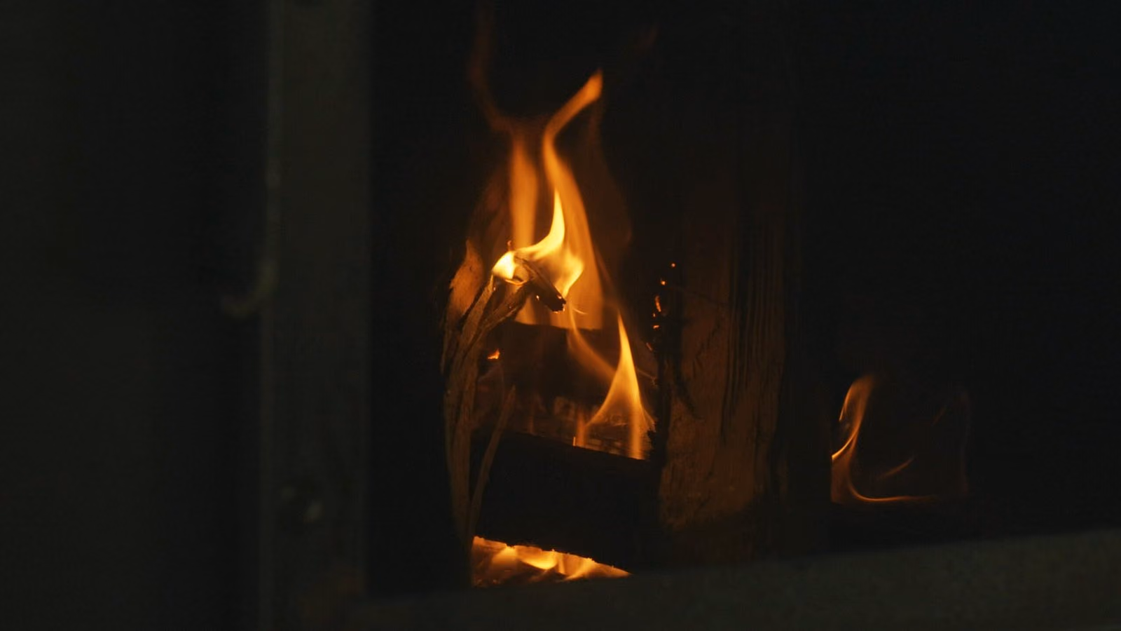 Braises et feu de bois rougeoyant dans le foyer
